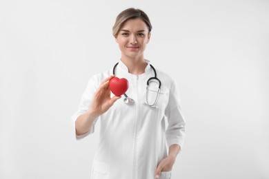 Photo of Doctor with stethoscope and red heart on white background. Cardiology concept