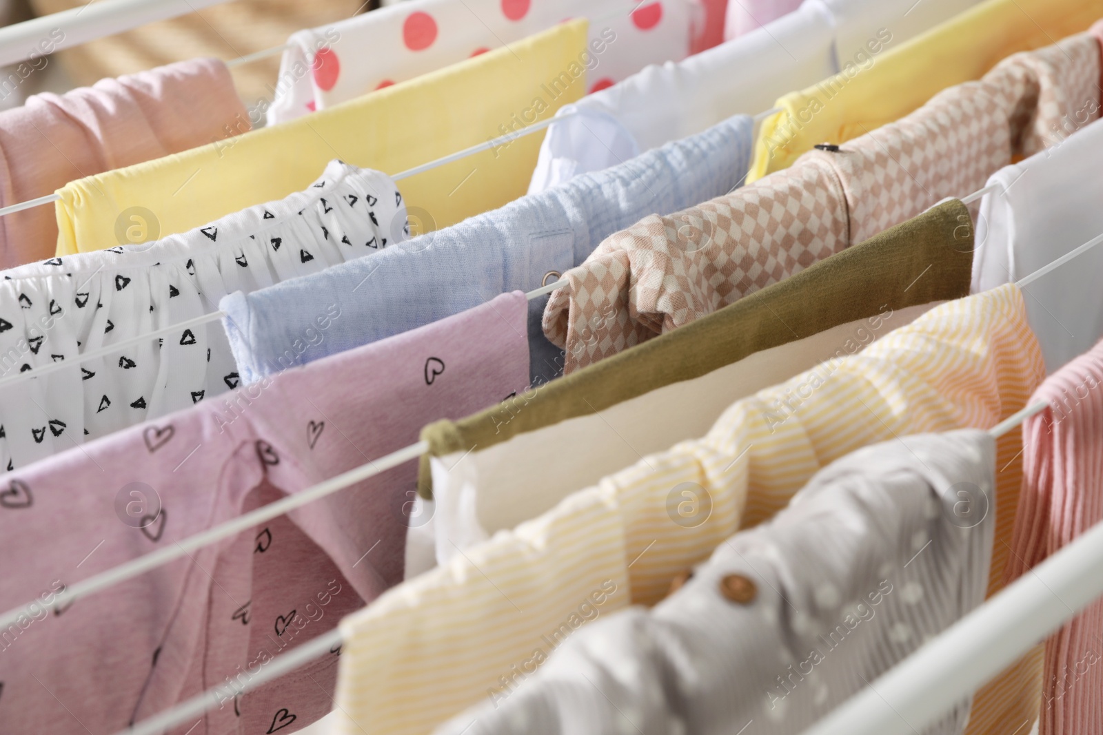 Photo of Clean laundry hanging on drying rack, closeup