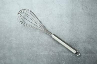 Photo of Metal whisk on gray table, top view