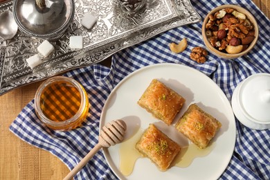 Delicious sweet baklava served on wooden table, flat lay