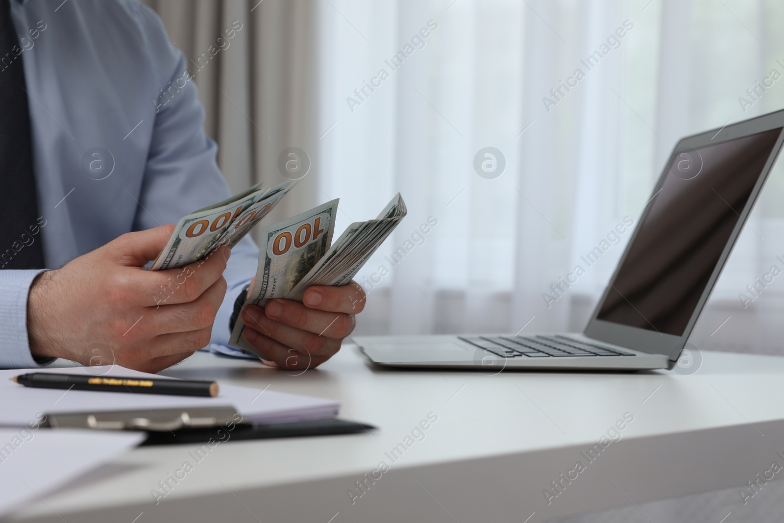Photo of Cashier counting money at desk in bank, closeup