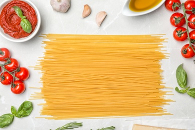 Photo of Beautiful composition with raw pasta and ingredients for sauce on table, top view