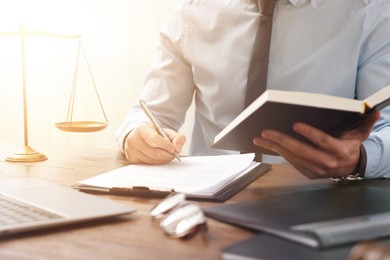 Image of Lawyer working with document at wooden table in office, closeup