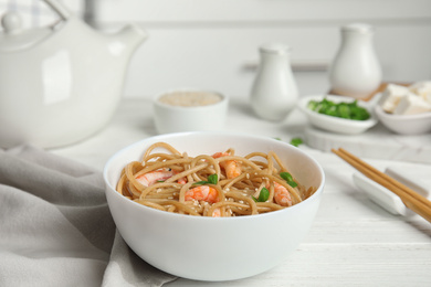 Photo of Tasty buckwheat noodles with shrimps served on white wooden table