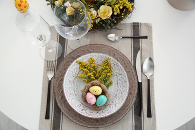 Festive Easter table setting with beautiful floral decor and eggs, flat lay