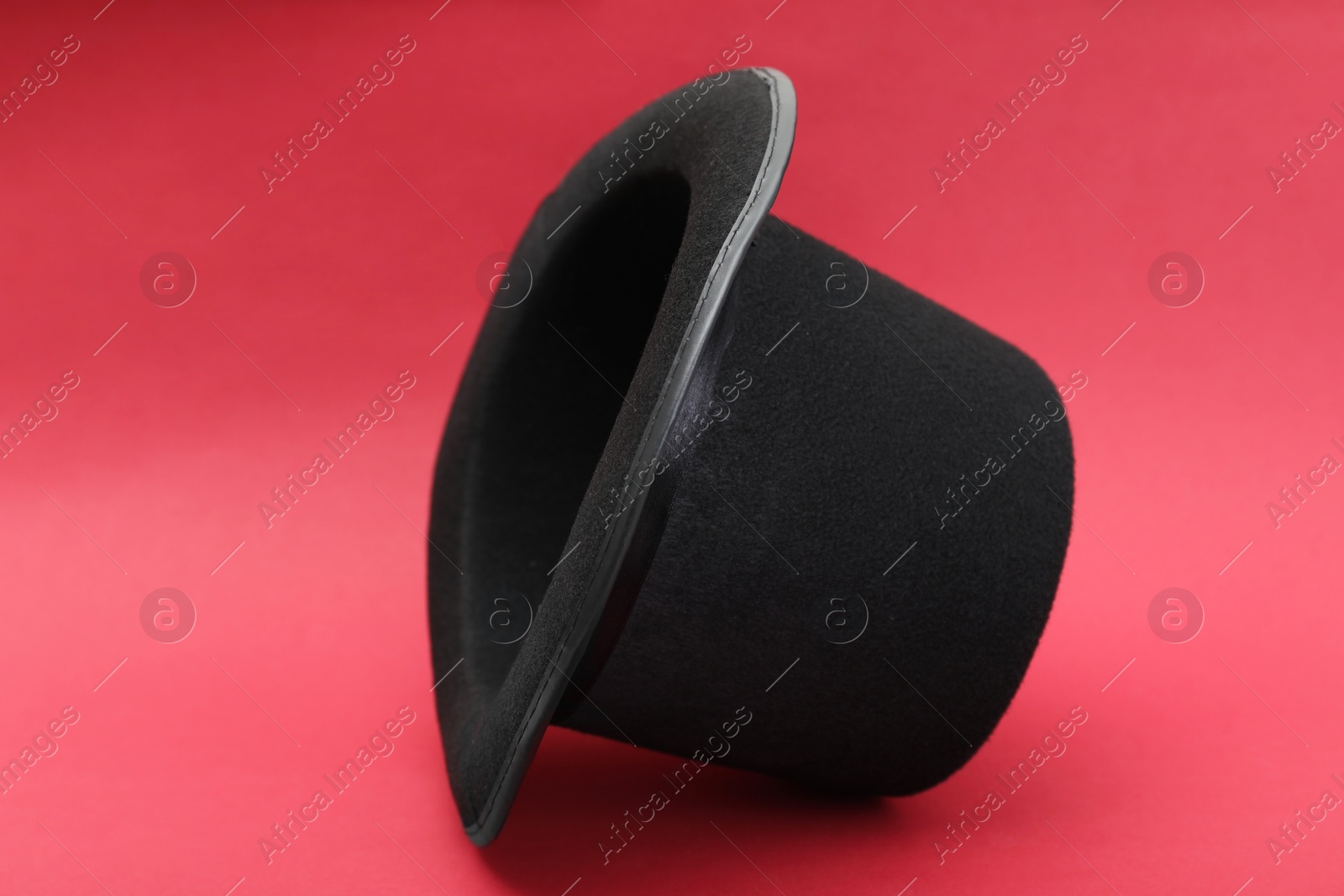 Photo of One magician top hat on red background