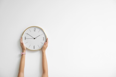 Woman holding clock on white background. Time concept