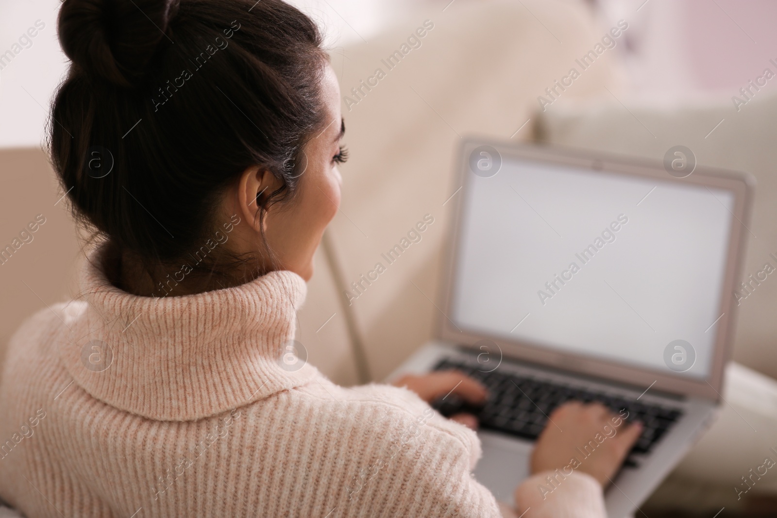 Photo of Beautiful young woman with laptop relaxing at home, closeup. Cozy atmosphere