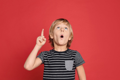 Photo of Portrait of cute little boy on red background