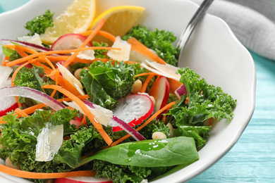 Photo of Tasty fresh kale salad on light blue wooden table, closeup