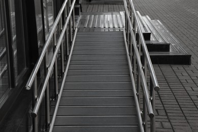 Ramp with metal railings near building outdoors