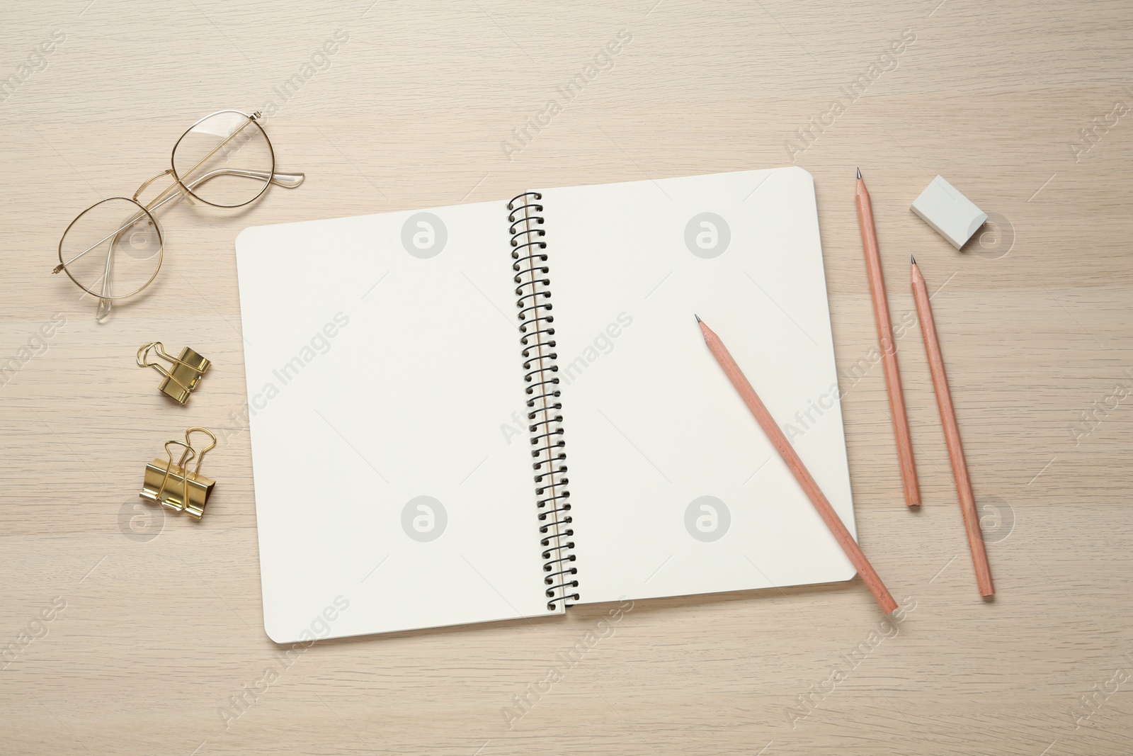 Photo of Flat lay composition with blank sketchbook on wooden table. Space for text