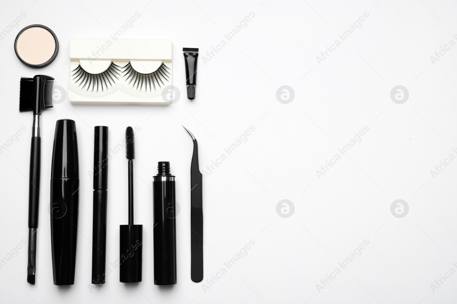 Photo of Composition with false eyelashes and other makeup products on white background, top view