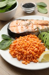 Photo of Plate with healthy food high in vegetable fats on wooden table, closeup