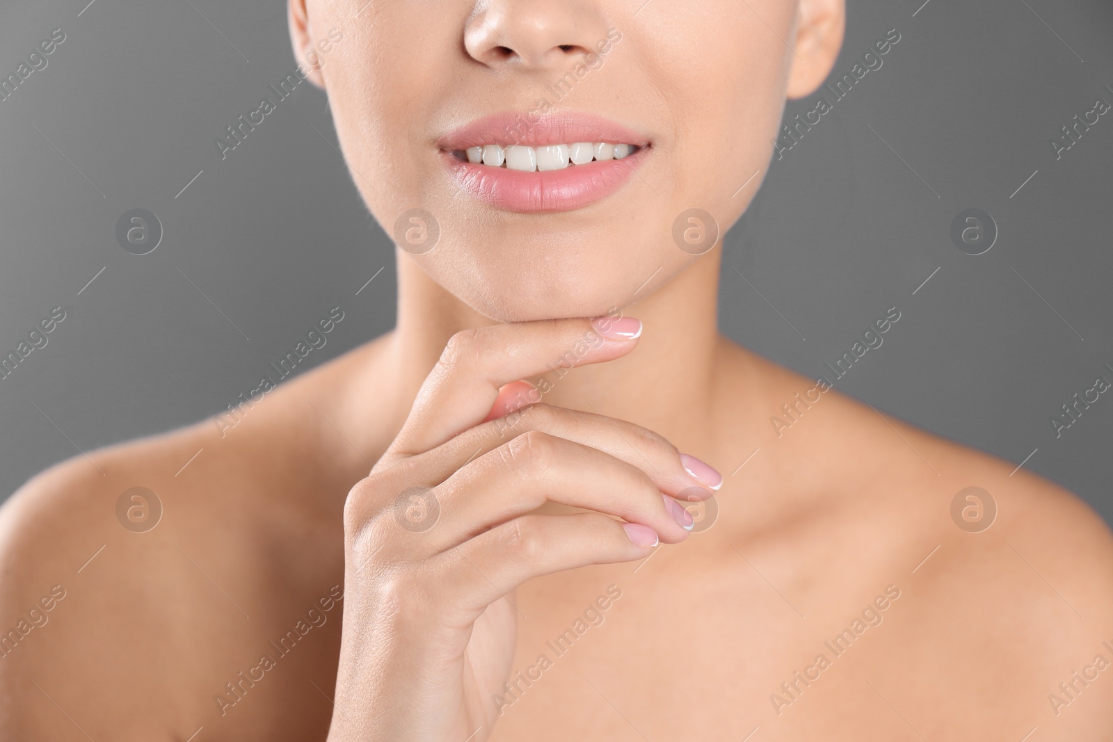 Photo of Closeup view of beautiful young woman on grey background. Lips contouring, skin care and cosmetic surgery concept