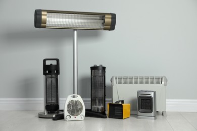 Photo of Different electric heaters near light grey wall indoors