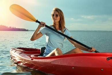 Beautiful woman kayaking on river. Summer activity