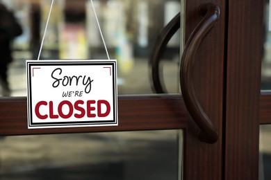 Image of Sorry we are closed sign hanging on glass door