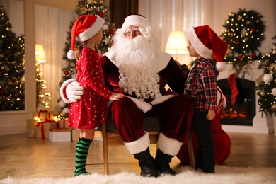 Santa Claus and children in room decorated for Christmas