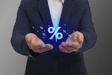 Image of Man showing virtual percent sign on grey background, closeup. Discount concept