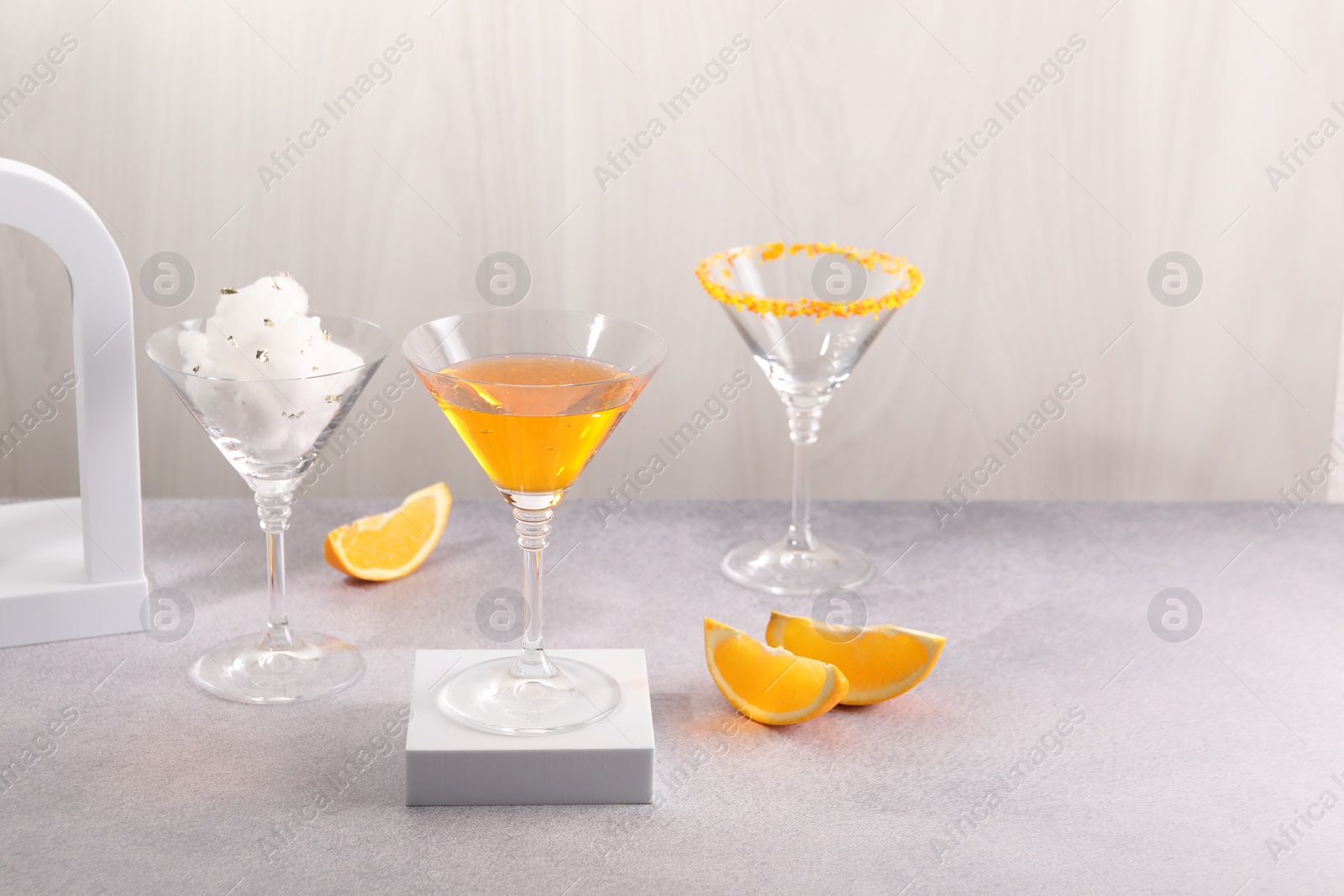 Photo of Cotton candy and cocktails in glasses on gray table, space for text