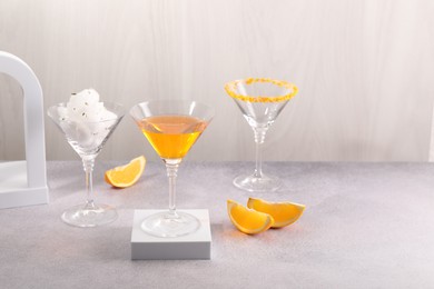 Photo of Cotton candy and cocktails in glasses on gray table, space for text