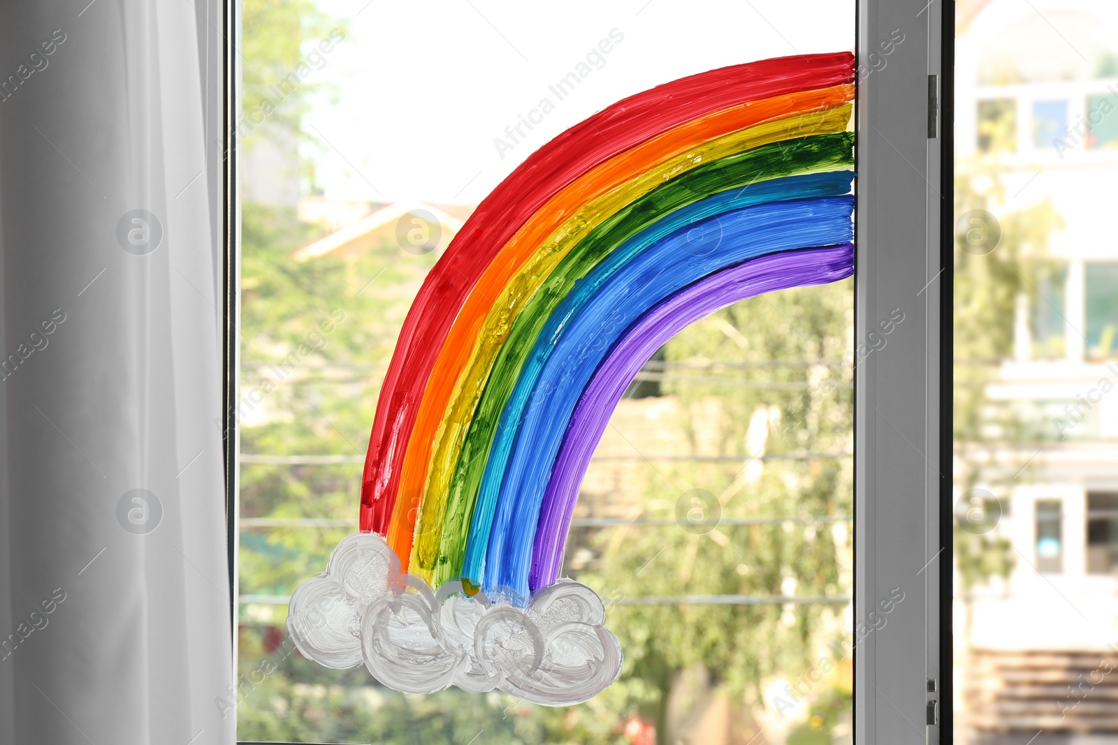 Photo of Picture of rainbow on window glass indoors. Stay at home concept