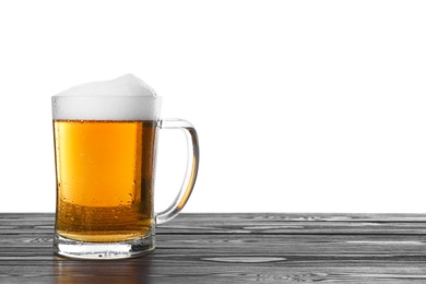 Photo of Glass mug of tasty beer on black wooden table against white background