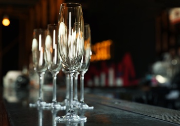 Empty clean champagne glasses on counter in bar. Space for text