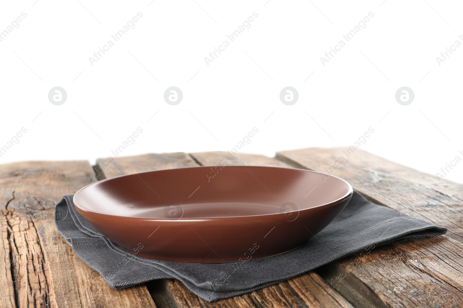 Photo of Empty brown plate and napkin on wooden table against white background