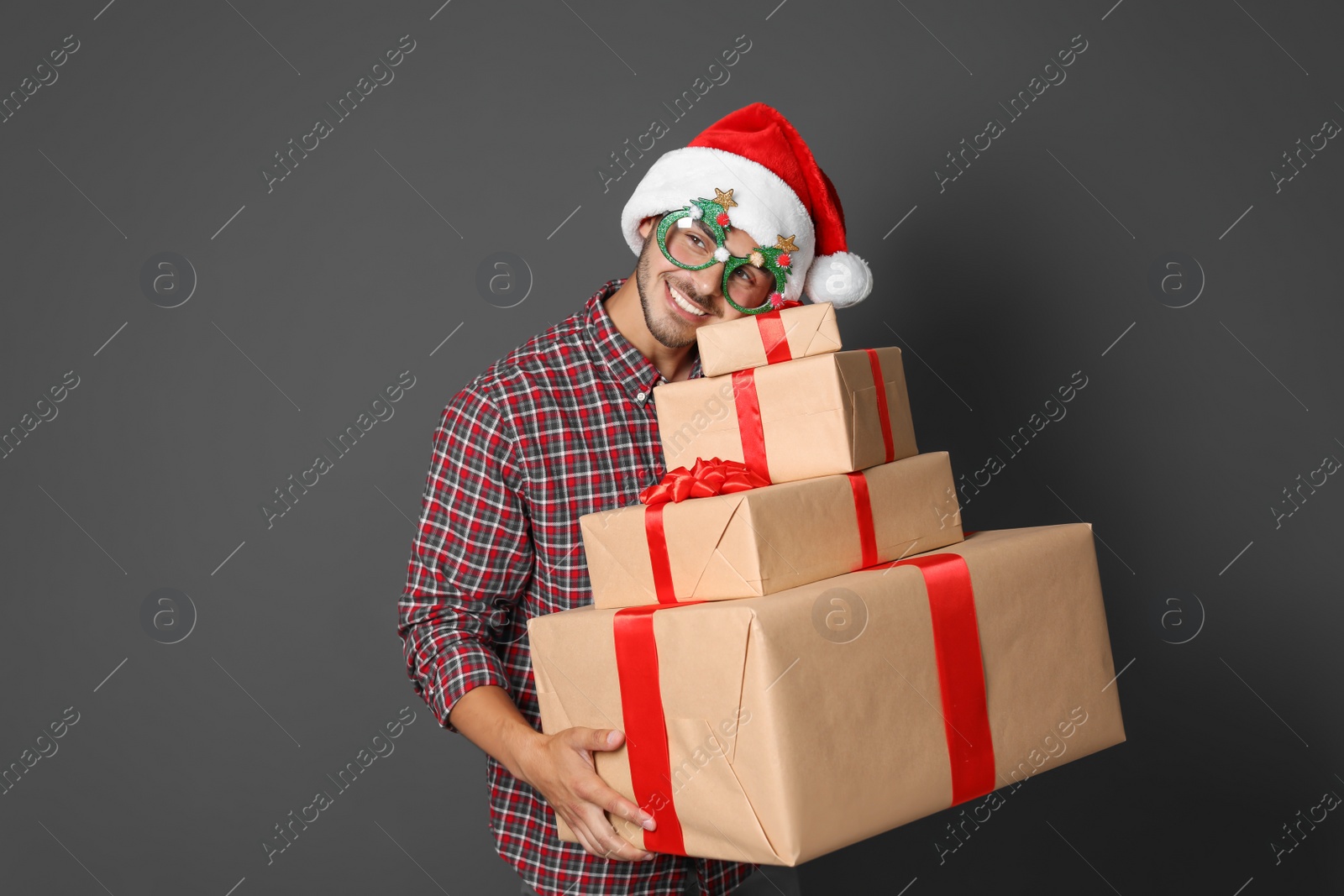 Photo of Young man with Christmas gifts on grey background