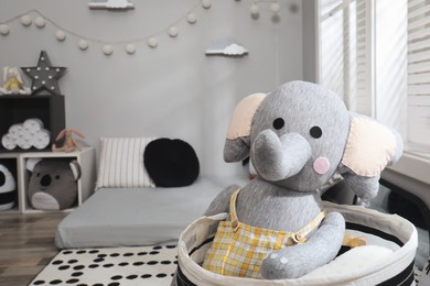 Photo of Cute toy elephant in Montessori bedroom, space for text. Interior design