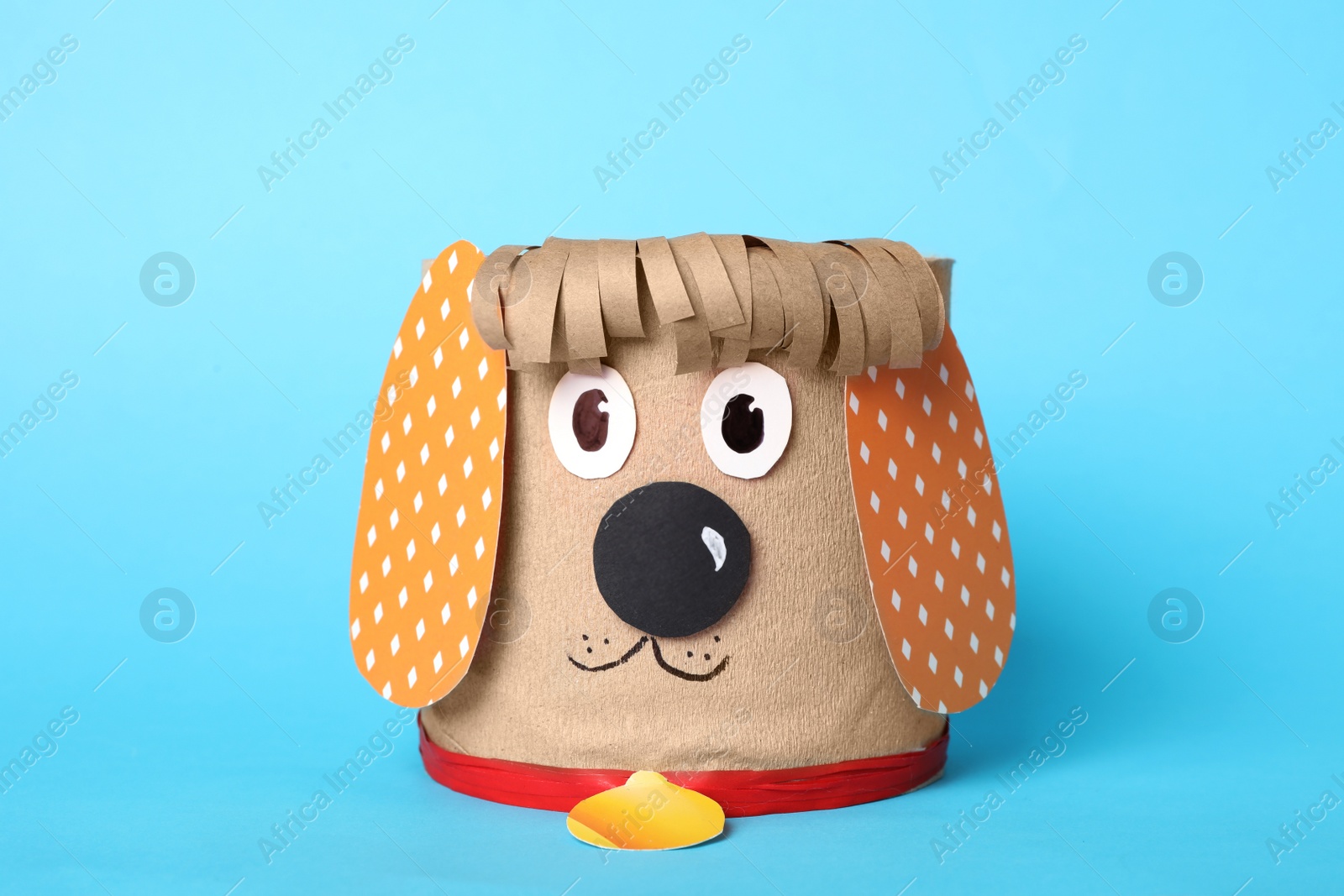 Photo of Toy dog made of toilet paper roll on light blue background