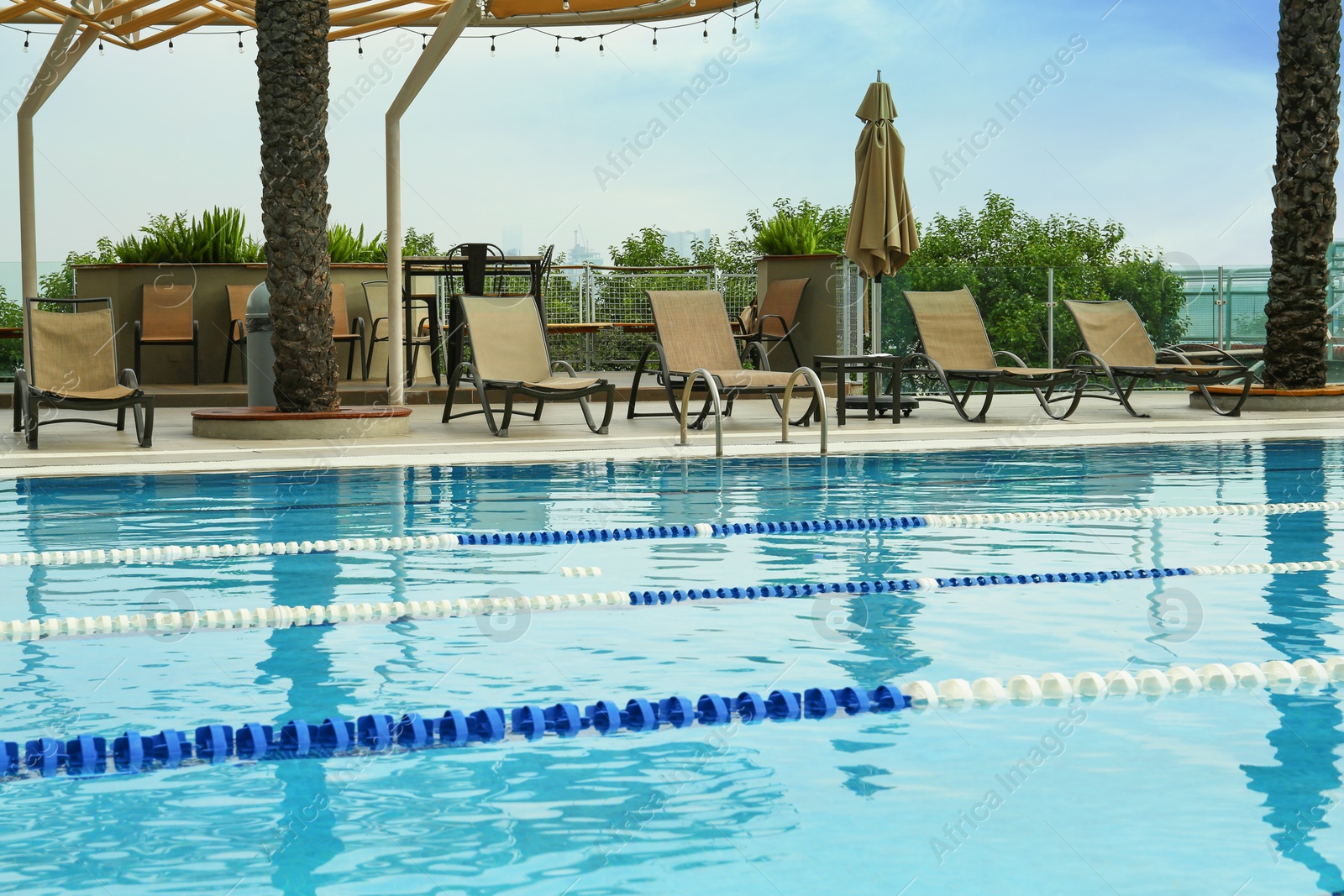 Photo of Swimming pool and sunbeds at luxury resort