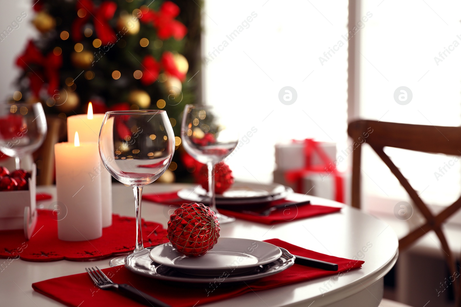 Photo of Festive table setting and Christmas tree in stylish room interior