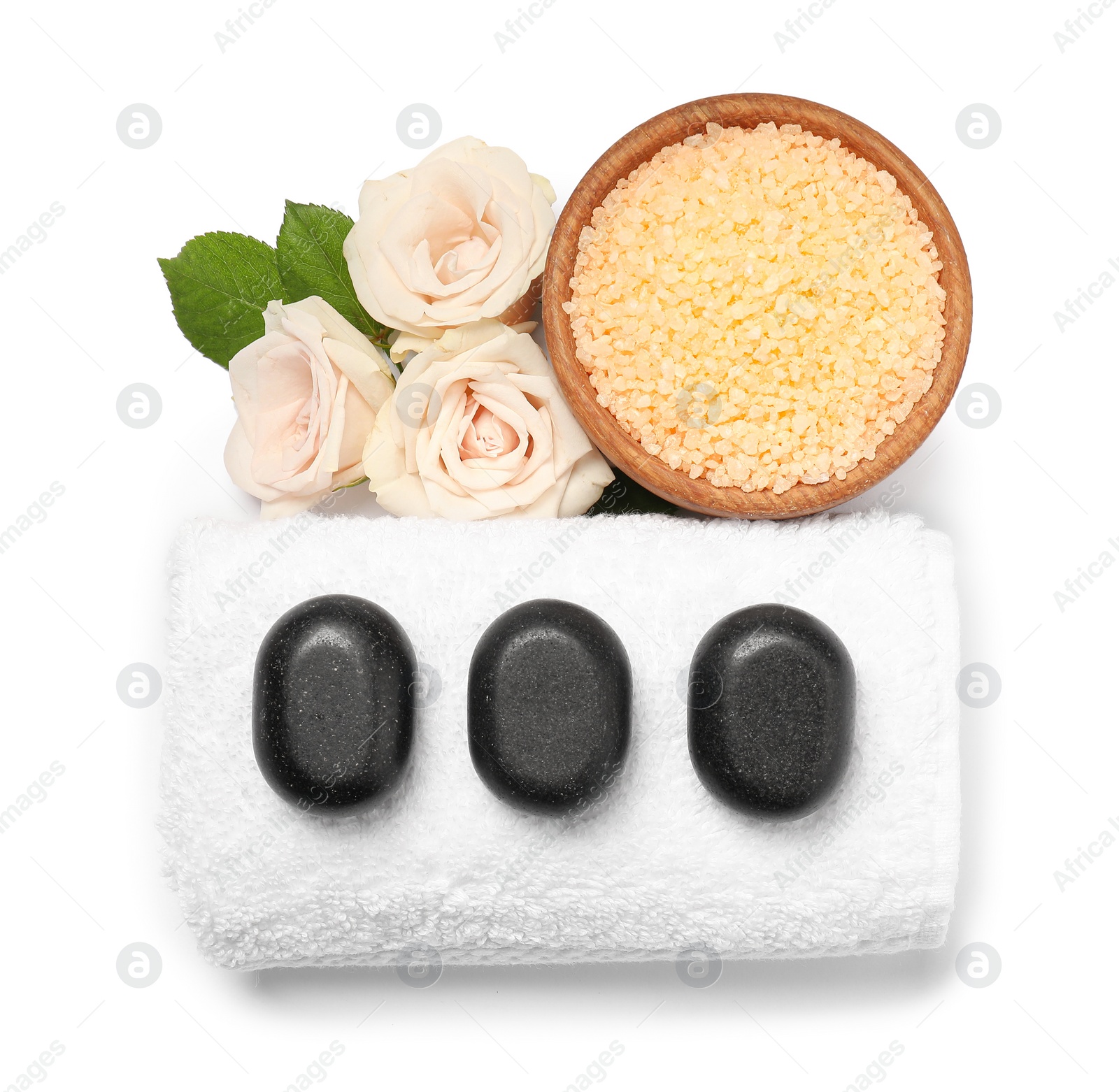 Photo of Orange sea salt in bowl, spa stones, towel and flowers isolated on white, top view