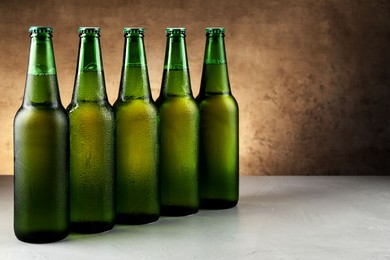 Many bottles of beer on white table, space for text