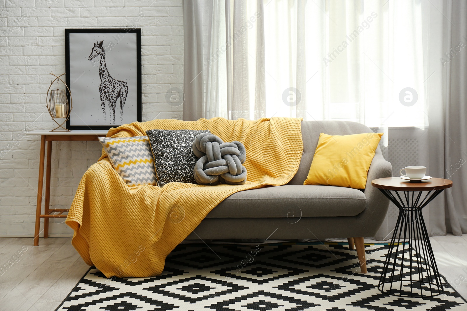 Photo of Stylish living room interior with soft pillows and yellow plaid on sofa
