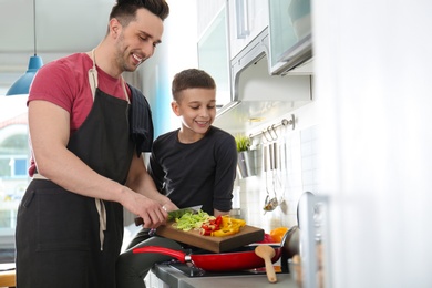 Dad and son cooking together in kitchen