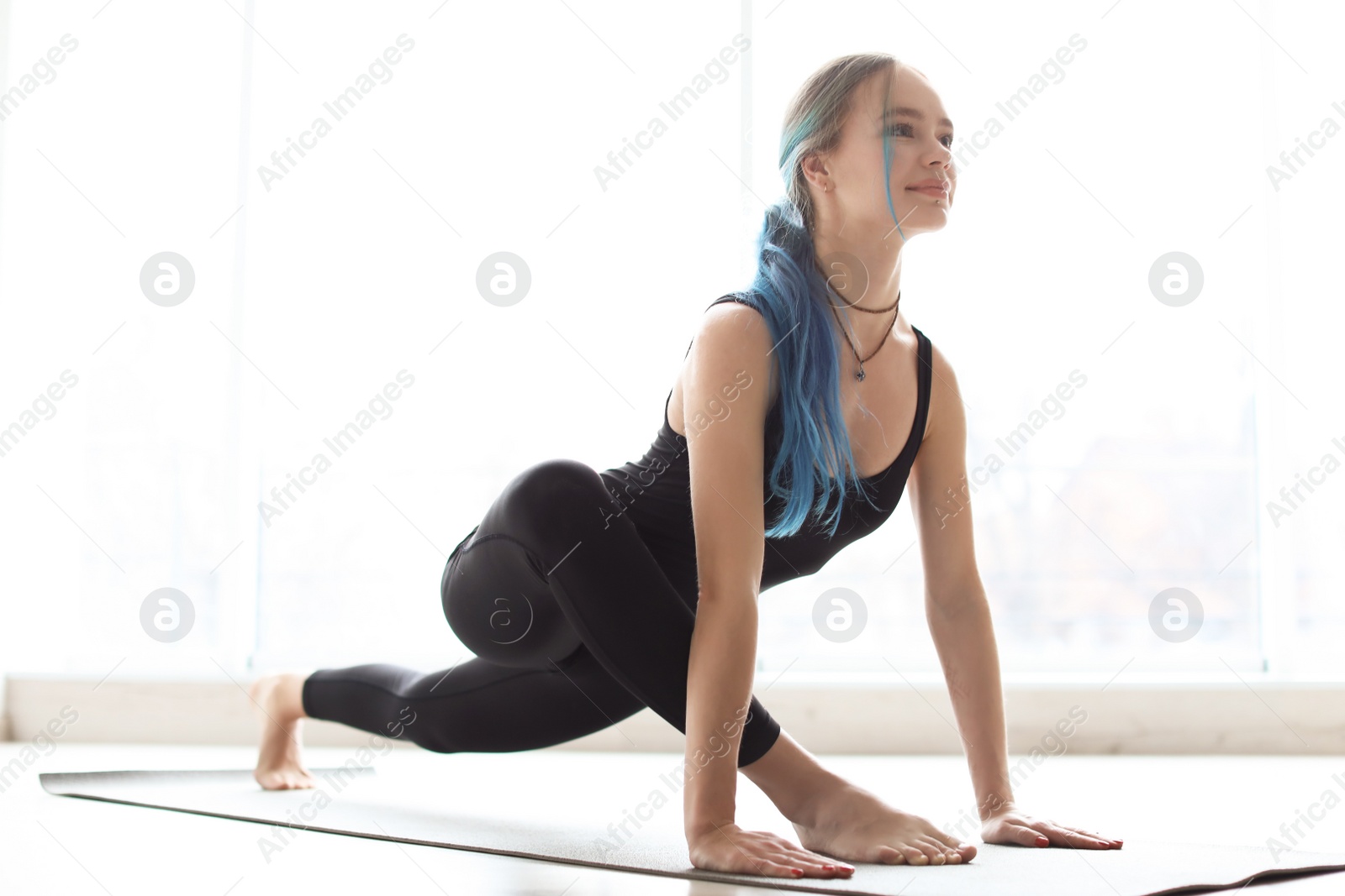 Photo of Young woman practicing yoga indoors