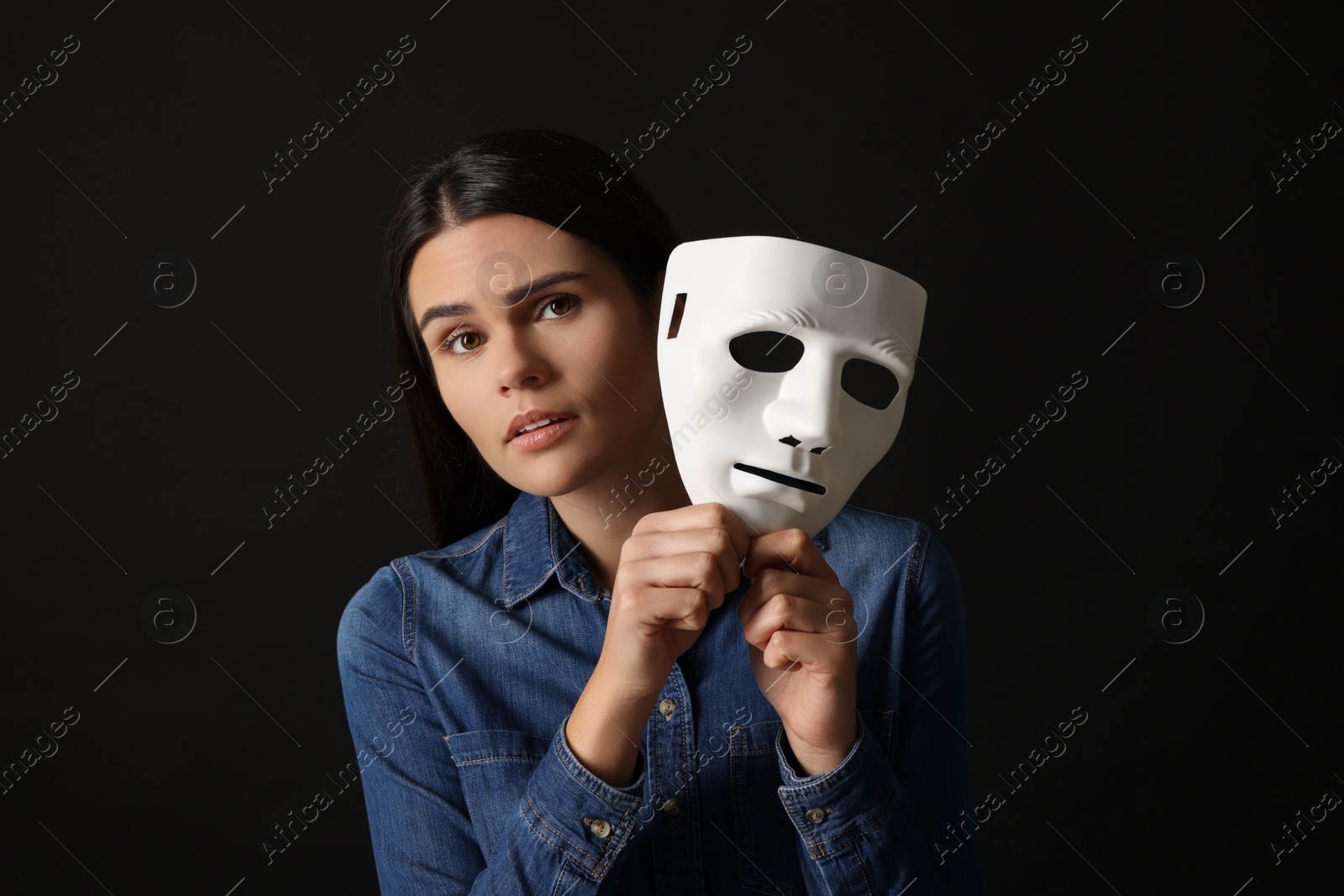 Photo of Multiple personality concept. Woman with mask on black background