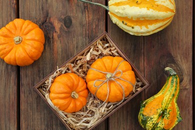 Photo of Crate and ripe pumpkins on wooden table, flat lay