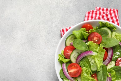 Photo of Delicious vegetable salad on light grey table, top view. Space for text