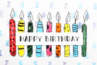 Photo of Card with words HAPPY BIRTHDAY and colorful drawn candles on paper sheet, top view