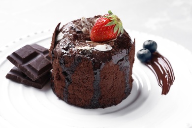 Delicious fresh fondant with hot chocolate and berries served on plate. Lava cake recipe