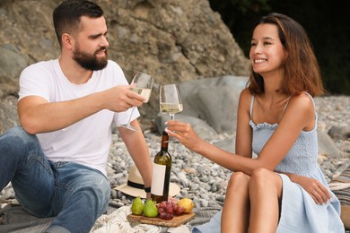 Photo of happy young couple having picnic on beach