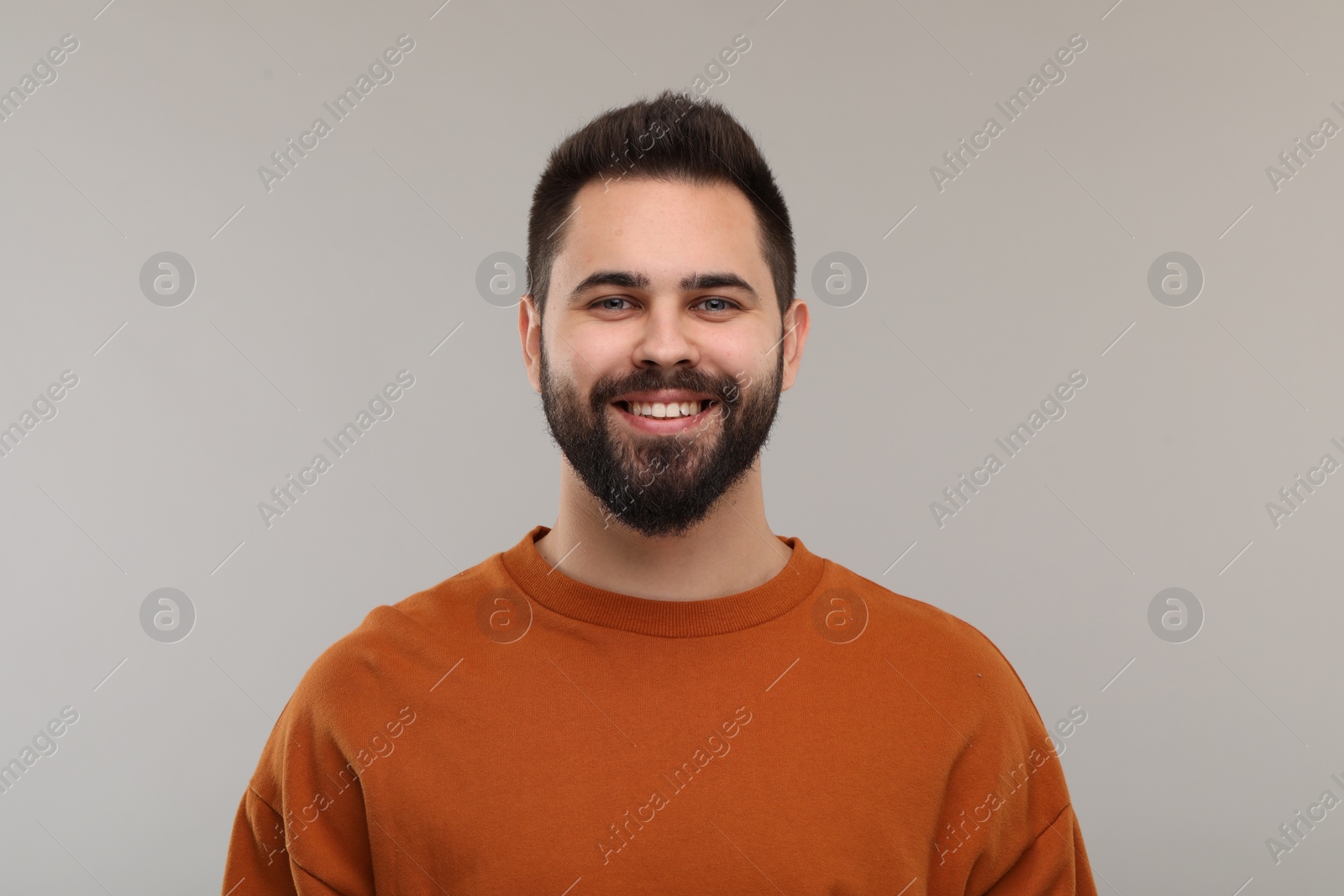 Photo of Man with clean teeth smiling on gray background