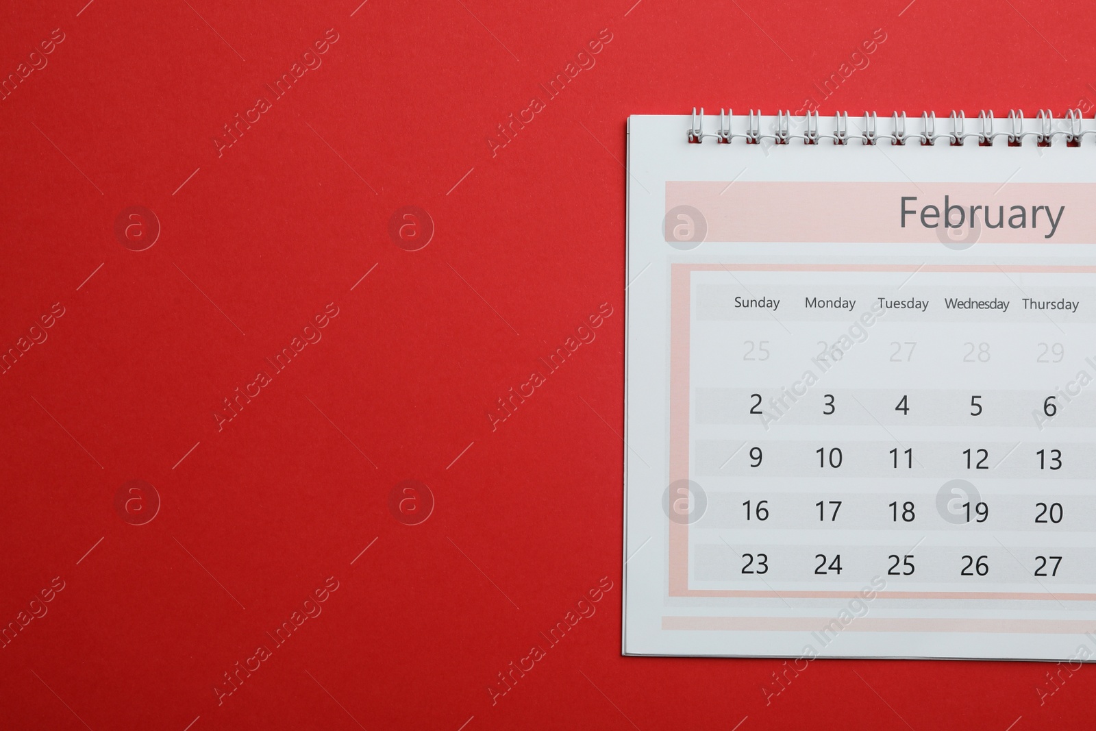 Photo of February calendar on red background, top view. Space for text