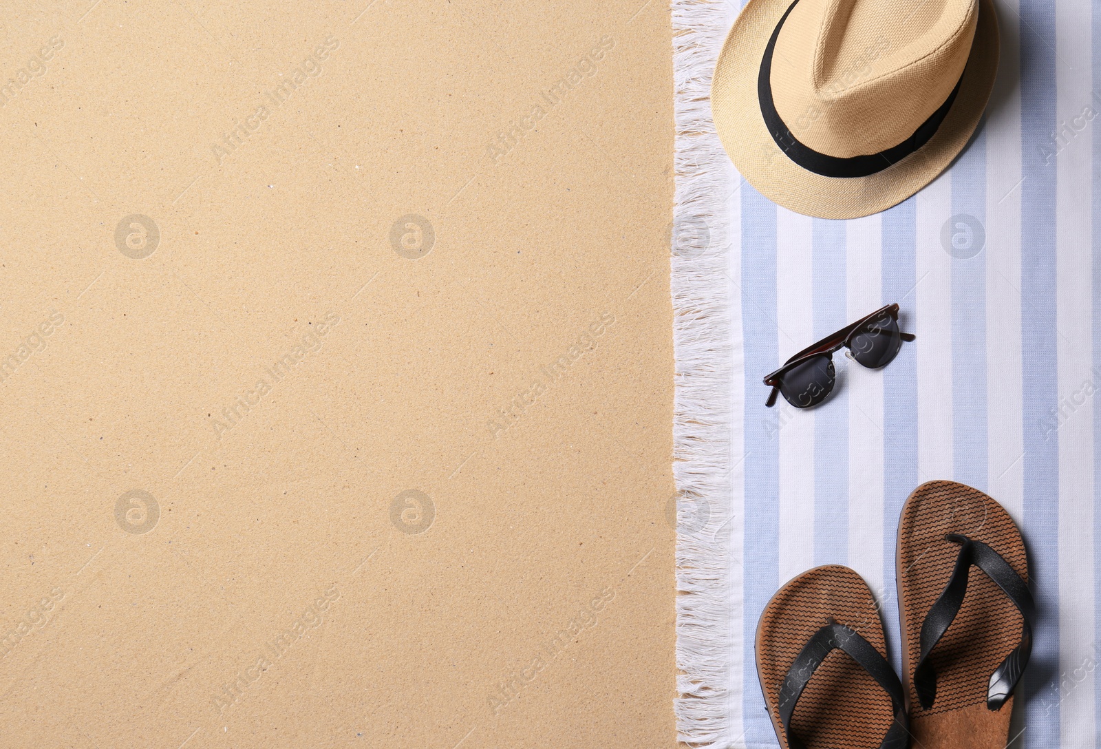 Photo of Beach accessories and space for text on sand, top view. Summer vacation