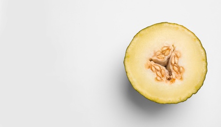 Photo of Half of ripe tasty melon on white background, top view